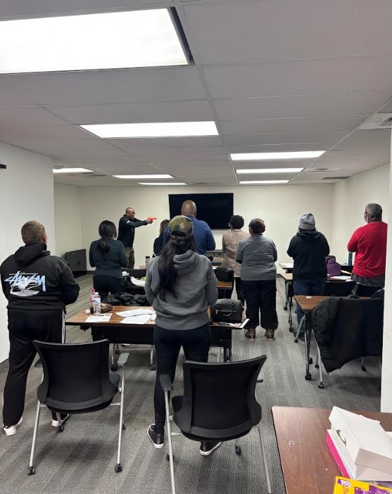 Instructor standing at the front of a classroom pointing toward a screen while students attend a Texas License to Carry in-person course with Gideon Training Solutions. State-approved Texas LTC class covering handgun laws, safety rules, and responsible carry practices. LTC instructor available in Dallas, Fort Worth, Mansfield, Arlington, Grand Prairie, DeSoto, and across all DFW and North Texas cities.