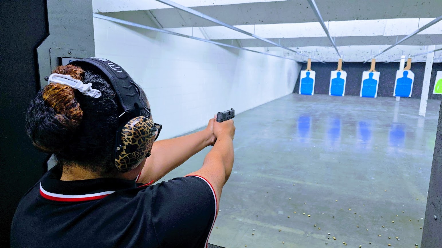 Student wearing hearing protection aiming a handgun at targets during a Texas License to Carry shooting qualification session with Gideon Training Solutions at a DFW area range. LTC shooting qualification available in Dallas, Fort Worth, Mansfield, Arlington, and across all DFW and North Texas cities.